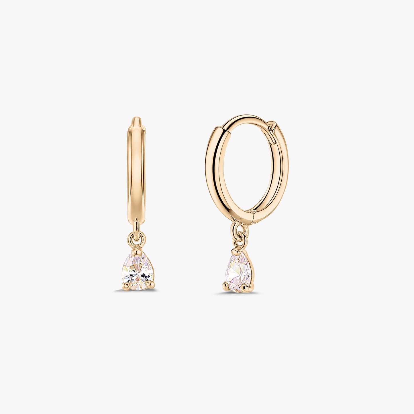 Двойка обеци халки тип huggie от жълто злато 14K с висящи бели цирконии с крушовидна шлифовка, на бял фон.