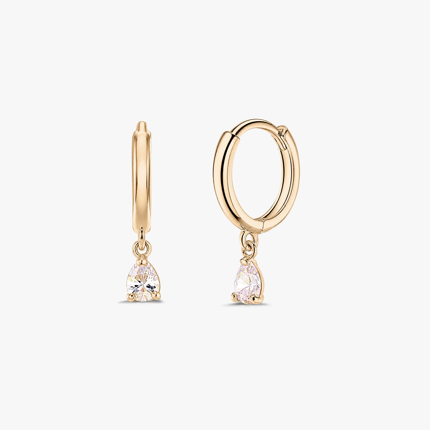 Двойка обеци халки тип huggie от жълто злато 14K с висящи бели цирконии с крушовидна шлифовка, на бял фон.