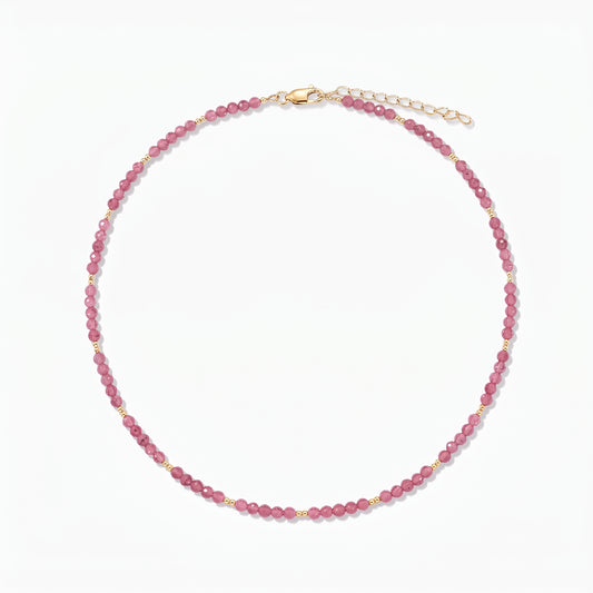 Сребърно колие Golden SummerScape – Tourmaline от Indira: колие с мъниста от розов турмалин, с малки златни акценти и карабинерна закопчалка с удължител, на бял фон.